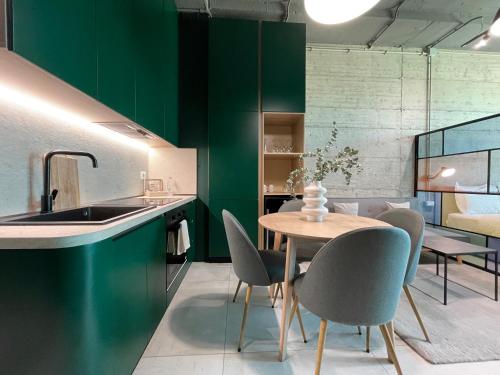 uma cozinha com paredes verdes e uma mesa e cadeiras em Ambassador Skyline Apartments em Tirana