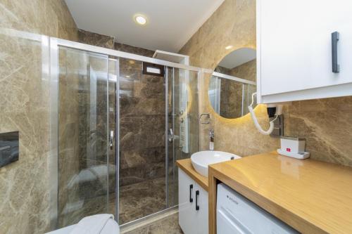 a bathroom with a shower and a sink at Sea and Nature View Cozy Flat with Pool in Kas in Kas