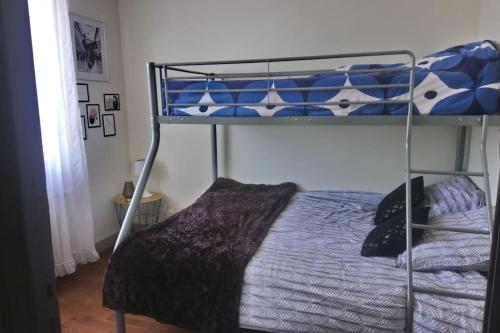 Dormitorio con litera y edredón azul en Maison familiale à 10 min du Mont Saint Michel en Pontorson
