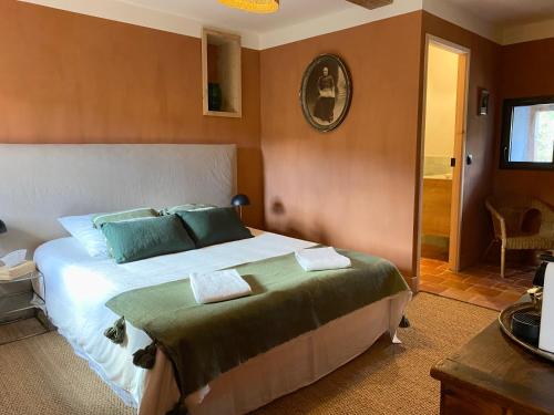ein Schlafzimmer mit einem großen Bett mit grünen Kissen in der Unterkunft Cévennes - Splendide chambre d'hôtes, indépendante et moderne in Monoblet