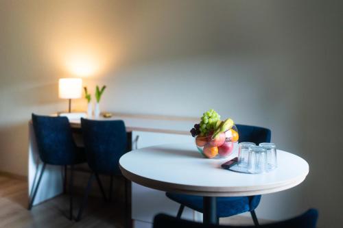 a small white table with a bowl of fruit on it at Aparthotel Stralsund Studios und Apartments in Stralsund