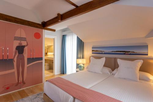 a bedroom with a bed and a painting of a woman on a surfboard at Hotel Sol Boutique in Santander