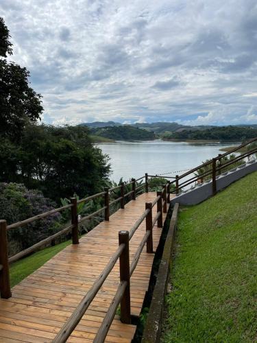 a wooden boardwalk with a view of a lake at Chalé das Águas in Igaratá