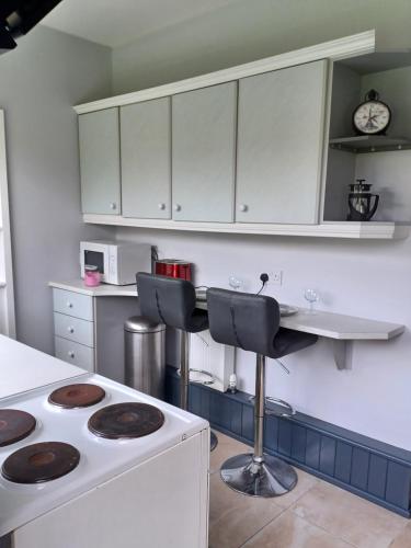 a kitchen with white cabinets and a stove top oven at Eva Lodge in Tralee