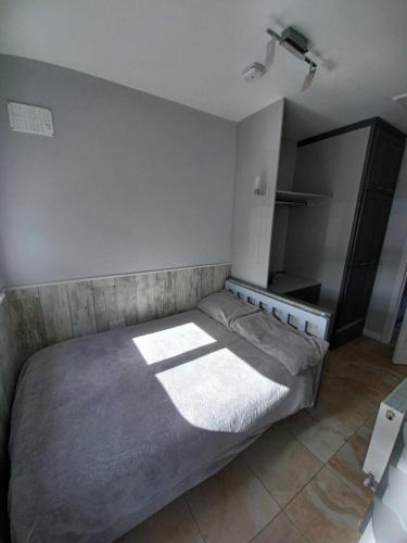 1 dormitorio con 1 cama con manta gris en Eva Lodge, en Tralee