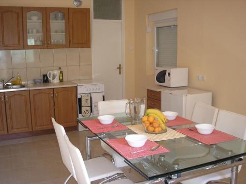 eine Küche mit einem Tisch und einer Obstschale darauf in der Unterkunft Villa Rosa in Donji Morinj