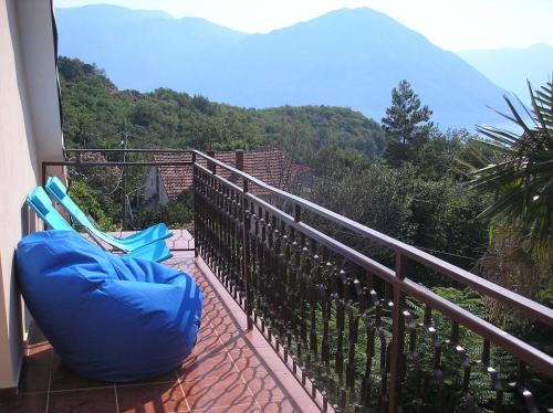 a balcony with a chair and a view of the mountains at Villa Rosa in Donji Morinj