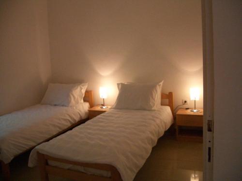 2 Betten in einem Zimmer mit 2 Lampen an Tischen in der Unterkunft Villa Rosa in Donji Morinj
