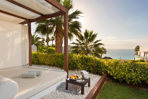 una cama en un patio trasero con el océano en el fondo en Esencia de Fuerteventura by Princess, en Playa de Jandía