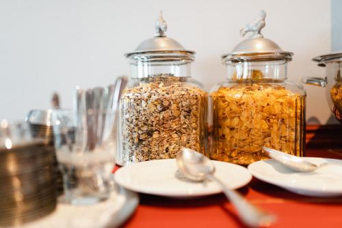 two jars of granola on a table with spoons at Hotel am Denkmal Norderney in Norderney