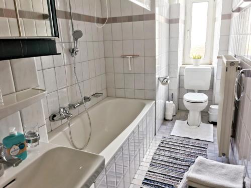 baño blanco con bañera y aseo en Villa Rosen - Ferienwohnungen, en Bad Reichenhall