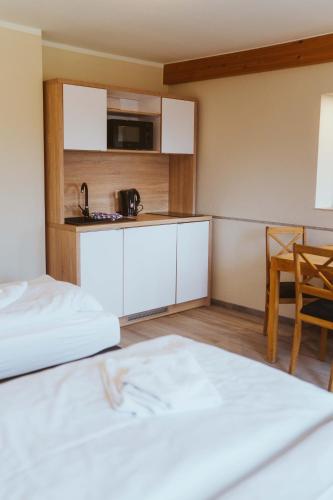 a hotel room with two beds and a kitchen at Aparthotel Stralsund Studios und Apartments in Stralsund