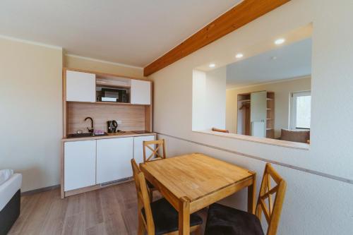 a kitchen and dining room with a table and a mirror at Aparthotel Stralsund Studios und Apartments in Stralsund