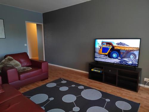 uma sala de estar com uma televisão de ecrã plano e um sofá em Tampsan Lake em Kotka