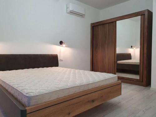1 dormitorio con 1 cama grande y espejo en Beautiful apartment in Tivat en Tivat