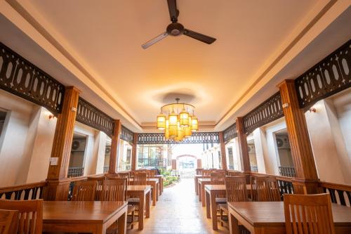 a dining room with tables and chairs and a ceiling fan at Peacock De Pai Hotel in Pai