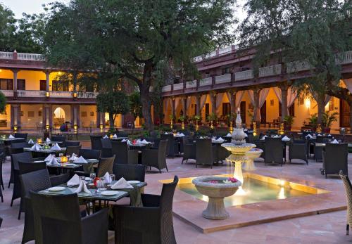 a restaurant with tables and chairs and a fountain at Ranbanka Palace in Jodhpur