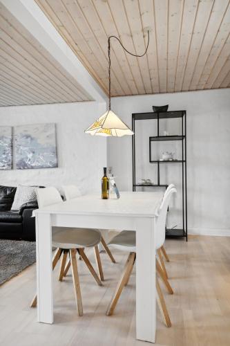 a white dining room with a white table and chairs at City Harbour House in Sønderborg
