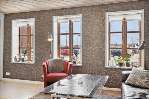 een woonkamer met een tafel, stoelen en ramen bij City Harbour House in Sønderborg
