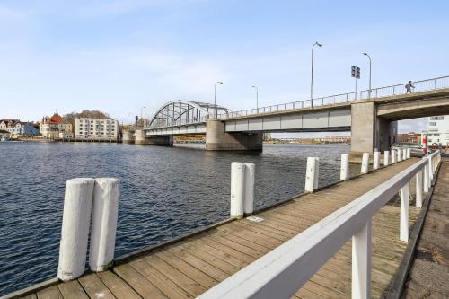 a bridge over a river with a wooden dock at City Harbour House in Sønderborg