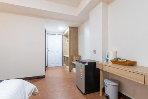 a room with a bed and a desk and a refrigerator at Peacock De Pai Hotel in Pai