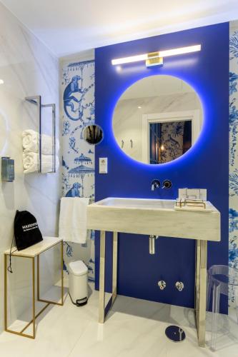 a blue bathroom with a sink and a mirror at Hotel Sol Boutique in Santander