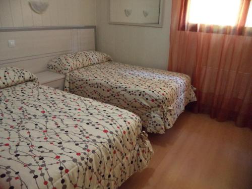 a bedroom with two beds and a window at Hotel A Santiago in Belorado