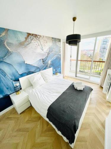 a bedroom with a large bed with a painting on the wall at Superbe 50m² calme et élégant, proche Paris in Villejuif