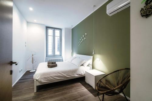 um quarto com uma cama branca e uma parede verde em Diaz 67 Life's Loft - The House Of Travelers em Como