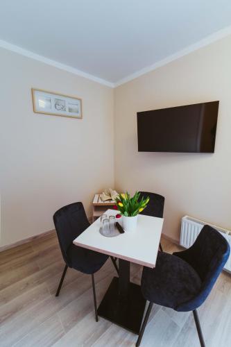 a dining room with a white table and two chairs at Aparthotel Stralsund Studios und Apartments in Stralsund