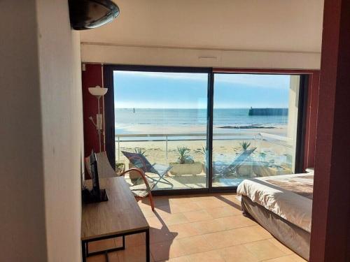 a bedroom with a view of a beach with a bed at Appartement d'une chambre a Quiberon a 200 m de la plage avec vue sur la mer balcon et wifi in Quiberon