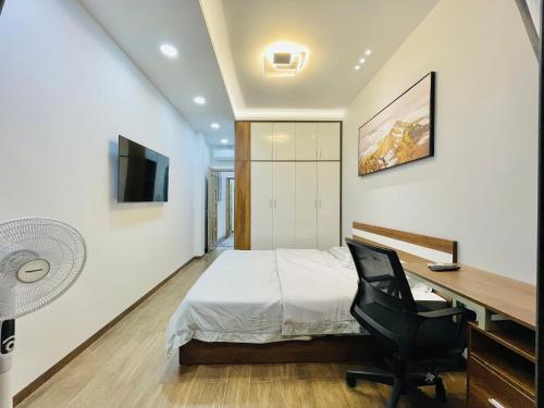 a bedroom with a bed and a desk and a chair at Thai Van Home in Ho Chi Minh City
