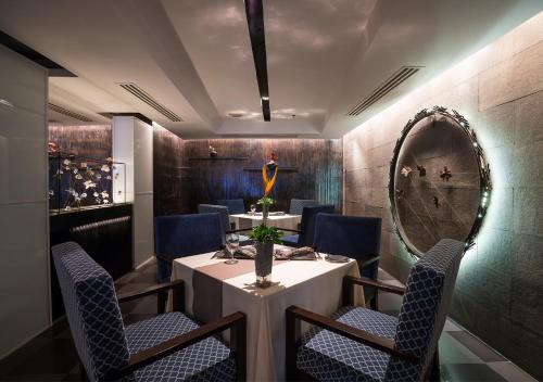 a dining room with a table and chairs and a mirror at Royal Wing Suites & Spa Pattaya in Pattaya South