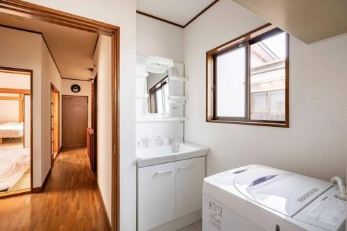 a small bathroom with a sink and a window at 世界遺産と東武日光駅に近い 全内装 3階まで階段あり 駐車場 子供不可 in Nikko