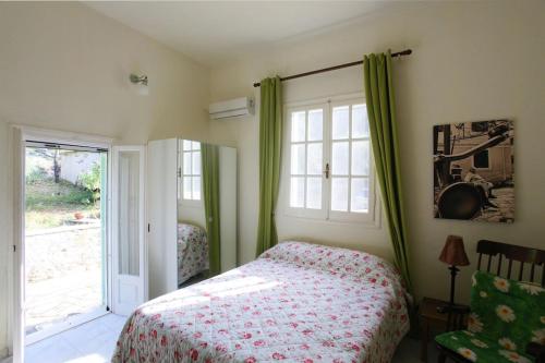 a bedroom with a bed and a large window at Villa Rex - A little piece of heaven! in Nisakion