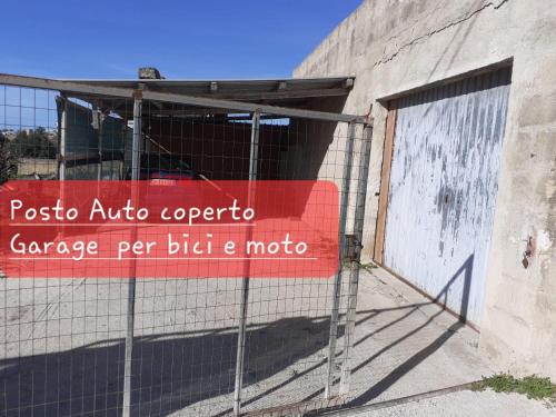 a sign on a fence in front of a building at A un Passo dal Tramonto in Marsala