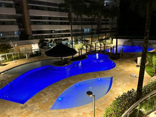 an empty pool with blue water in a building at Apartamento familiar em Riviera de São Lourenço Módulo 8 in Bertioga