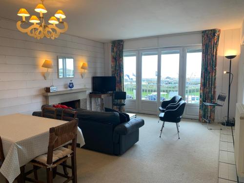 un salon avec un canapé, une table et des chaises dans l'établissement Appt de 6 pers - Vu mer proche centre-ville, à Le Touquet-Paris-Plage