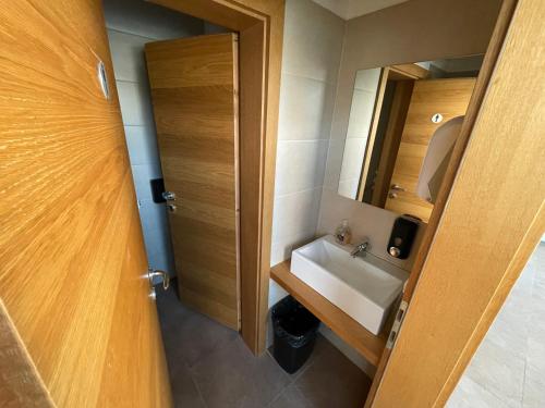 a small bathroom with a sink and a mirror at Sleep&Go Hostel Ljubljana in Ljubljana