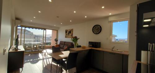 une cuisine et un salon avec une table et des chaises dans l'établissement Frejus Plage Le Mediterranee, Magnifique T2, 38m2,, à Fréjus