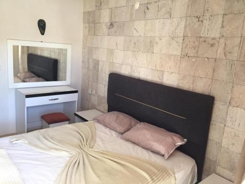 a bedroom with a bed with a stone wall at Safari Suit N-10 in Side