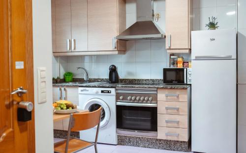 cocina con nevera blanca y lavavajillas en A Casa Antiga do Monte Apartamentos Turísticos - Pontecesures, en Padrón