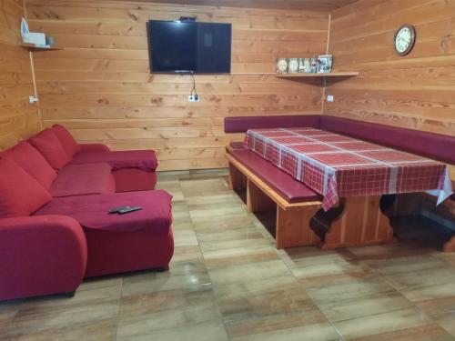 Cette chambre dispose d'un canapé, d'une table et d'une télévision. dans l'établissement Ranč Stojnšek, à Rogaška Slatina