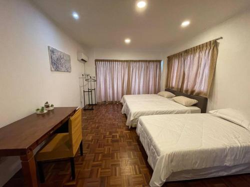 Cette chambre comprend deux lits et un bureau. dans l'établissement Lovely 4-rooms apartment in the heart of Kuching, à Kuching