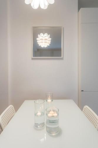 a white table with two candles and two glasses at White Candle Apt, Close to San Pietro, Gemelli and City Center in Rome