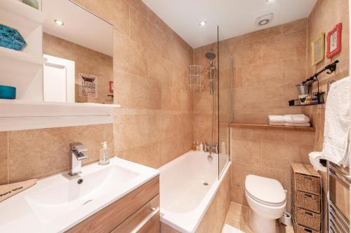 y baño con lavabo, aseo y bañera. en Notting Hill Bohemian Apartment, en Londres