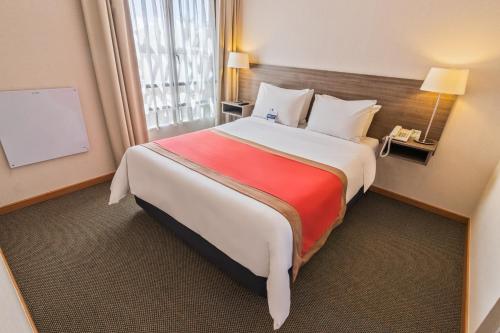 a hotel room with a large bed and a window at Geotel Calama in Calama