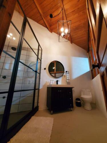 a bathroom with a sink and a mirror and a toilet at Casa Laguna: Best View In The World in Santa Cruz La Laguna