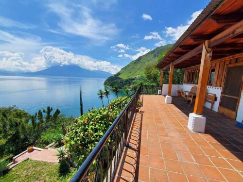 a house with a balcony with a view of the water at Casa Laguna: Best View In The World in Santa Cruz La Laguna