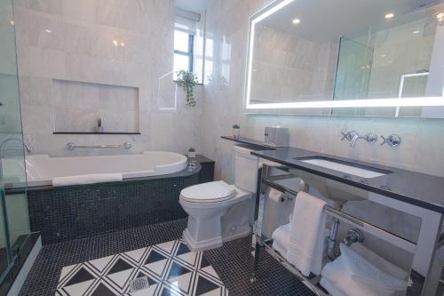 a bathroom with a tub and a toilet and a sink at Hotel Belleclaire Central Park in New York